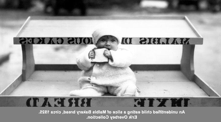 An unidentified child eating a slice of Malbis Bakery bread, circa 1925